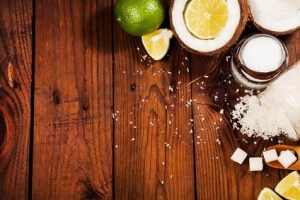 Homemade sugar scrub with lime and coconut on wooden background